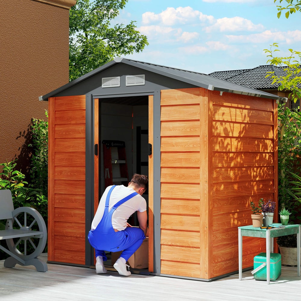 Man in blue overalls placing a box inside the garden shed with the sliding door open