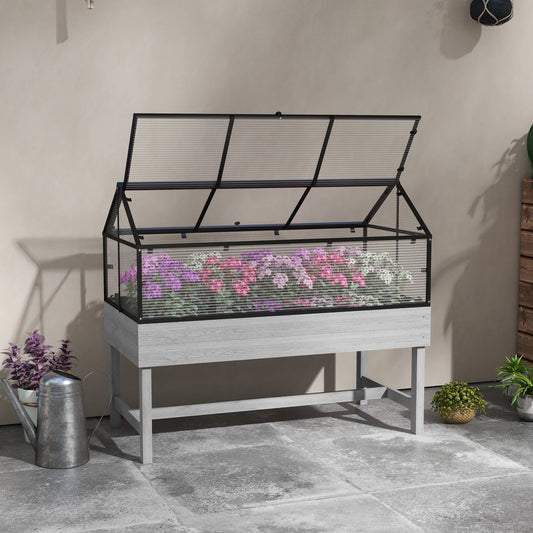 The raised garden bed placed on a patio with a watering can nearby