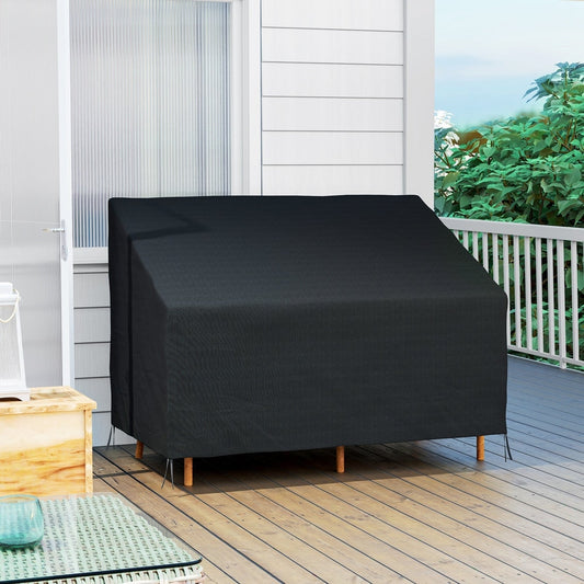 The outdoor furniture cover is on a sofa on a wooden deck with a white railing