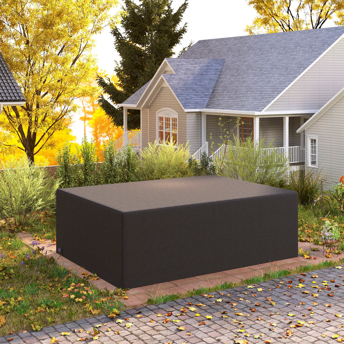 The black outdoor furniture cover is placed over a sofa set in an autumn garden setting
