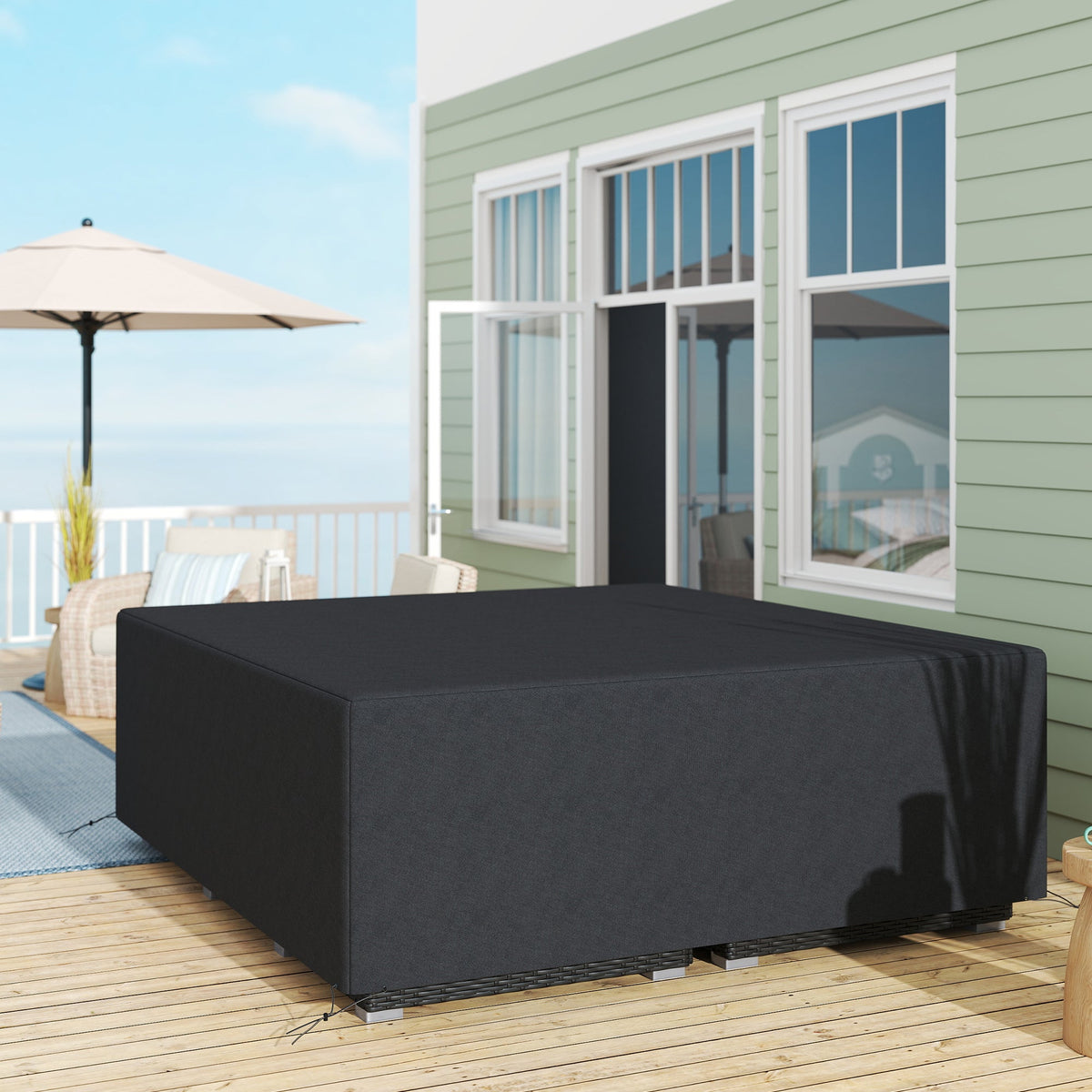 The protective cover draped over a large outdoor sofa set on a wooden patio deck