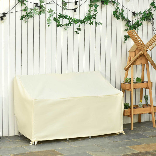 The beige outdoor sofa protector is shown on a patio with a wooden fence and plants