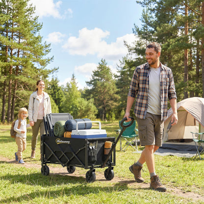 A family pulling the black collapsible wagon cart through a grassy campsite with tents and trees