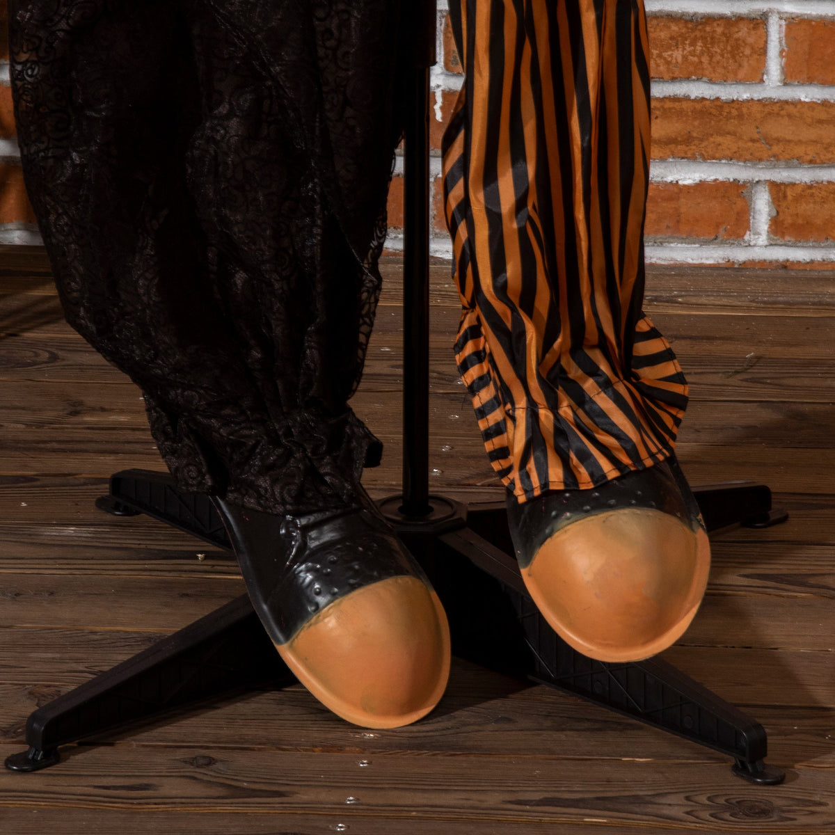 close up of the scary clown decoration's feet and stand showing its large shoes