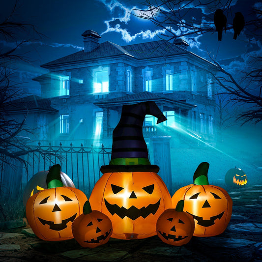 The inflatable pumpkin display glowing on a lawn in front of a spooky house at night
