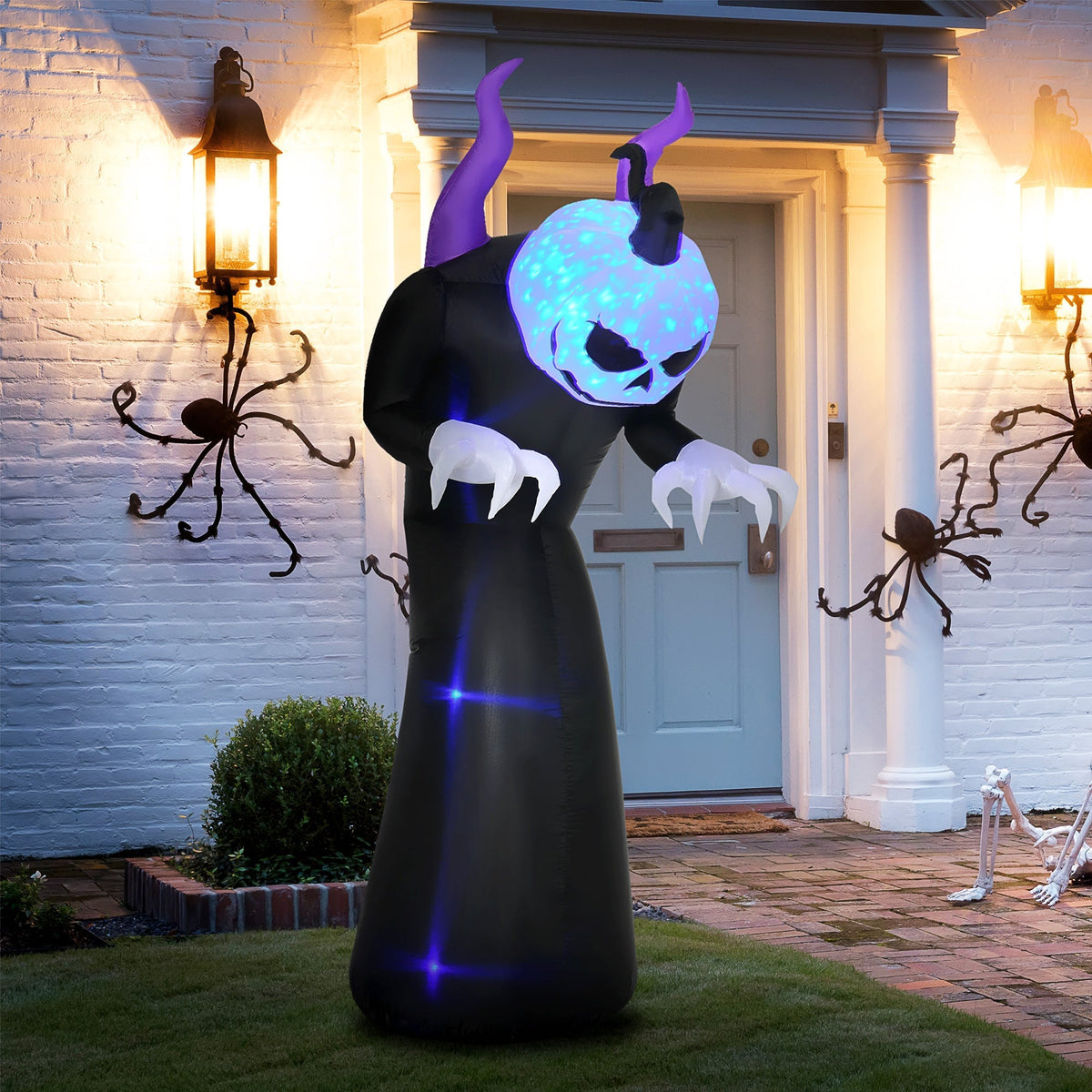 The Halloween inflatable ghost with horns standing on a lawn in front of a house at night