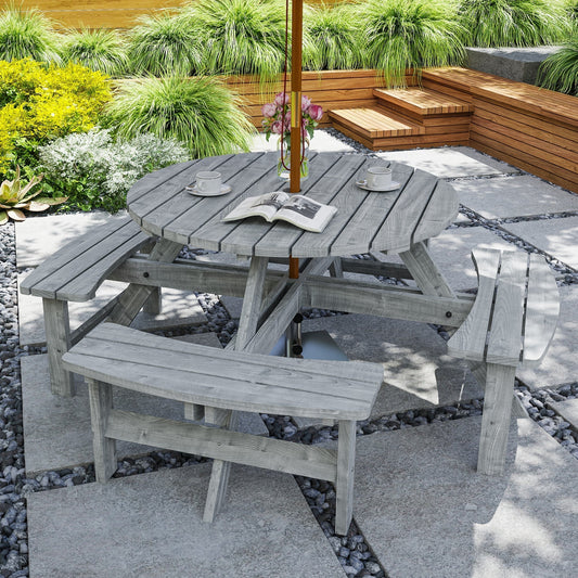 The wooden picnic set in use on a patio with cups and a book on the table