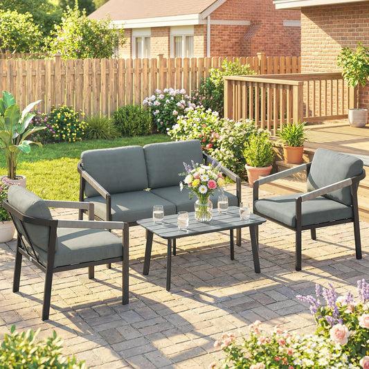 This garden furniture set is arranged on a patio with a wooden fence and plants