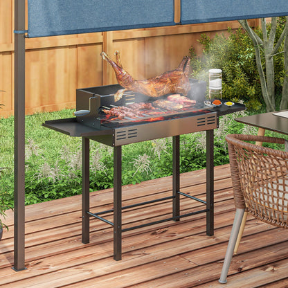 The charcoal grill in use on a wooden deck with meat cooking on the rotisserie spit