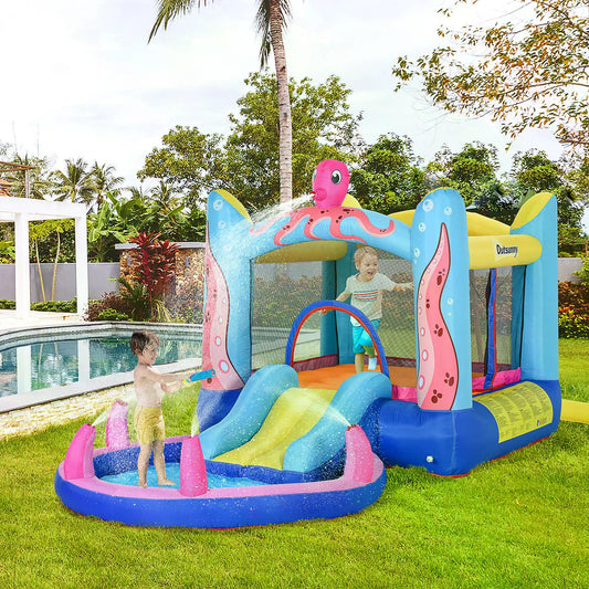 The bouncy castle set up on a green lawn next to a swimming pool with children playing inside
