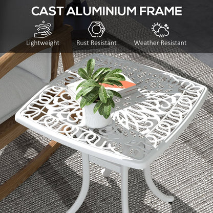 The white square garden table has a decorative patterned top and a central hole for an umbrella