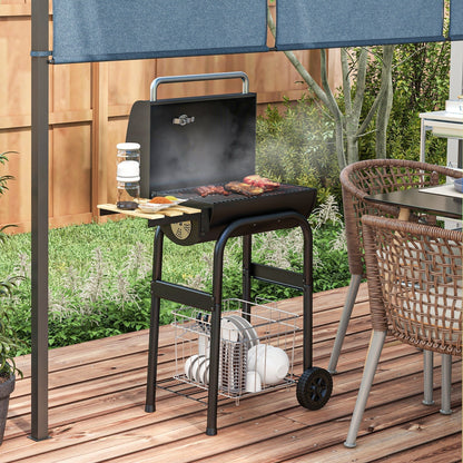 The charcoal grill in use on a wooden patio with food cooking on the hot metal grate