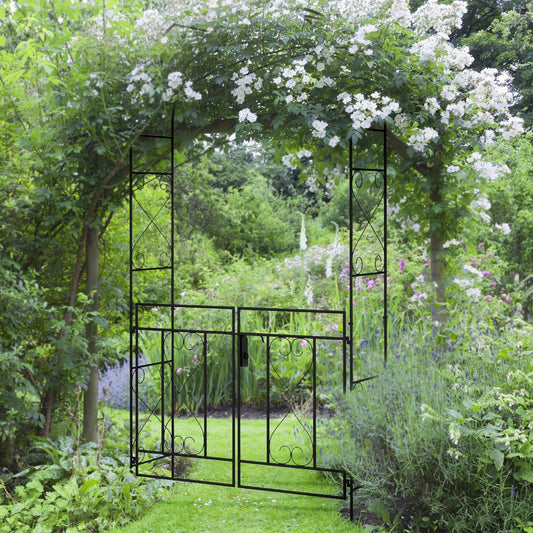 The black metal garden arch with double gate is shown in a garden setting with climbing plants