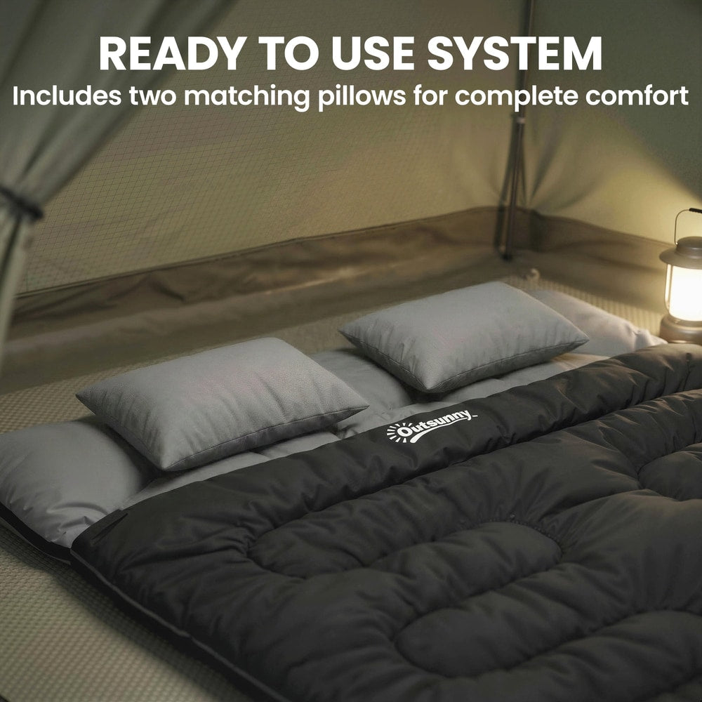 The camping bed with two pillows laid out on the floor inside a tent