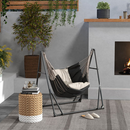 The portable hammock set up as a hammock chair on a patio with a striped cushion