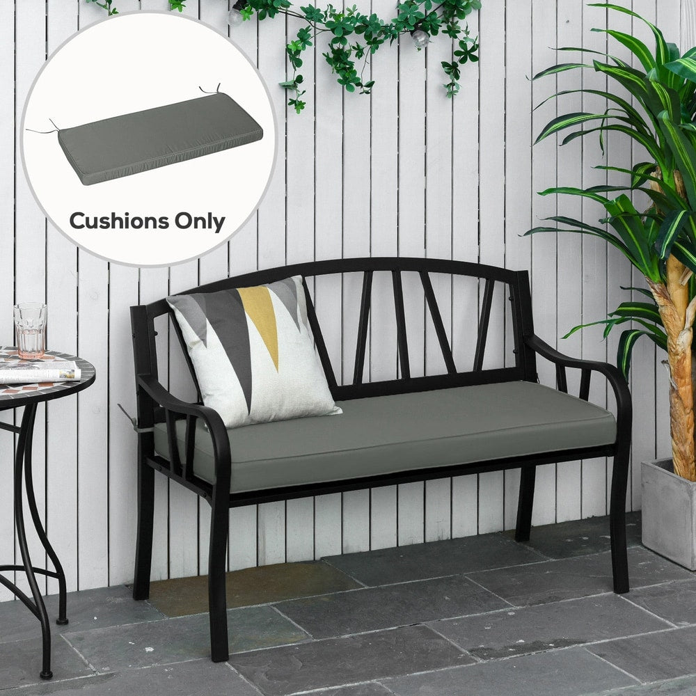 The grey garden bench cushion on a black metal bench outdoors with plants