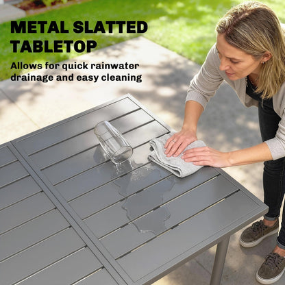 A close up of a metal slatted tabletop being wiped clean with a cloth after water is spilled
