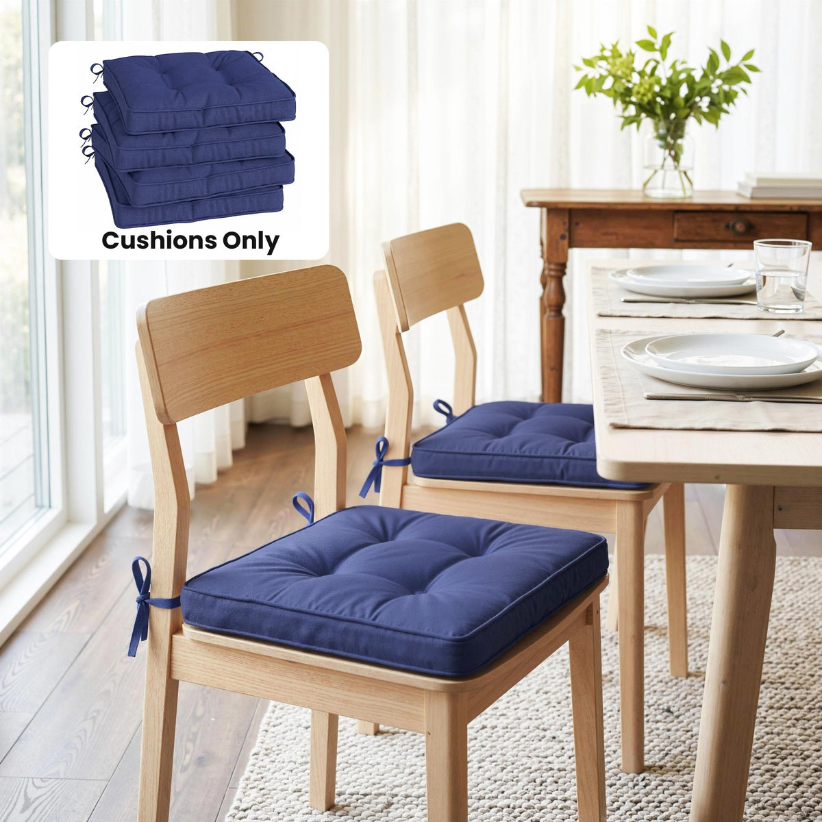Two dark blue dining chair seat pads with ties on light wood chairs at a table indoors