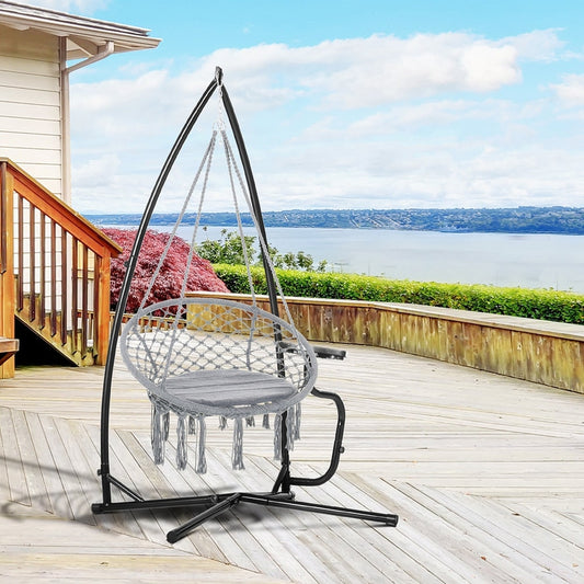 The metal hammock chair stand holding a grey woven hanging chair on a wooden deck