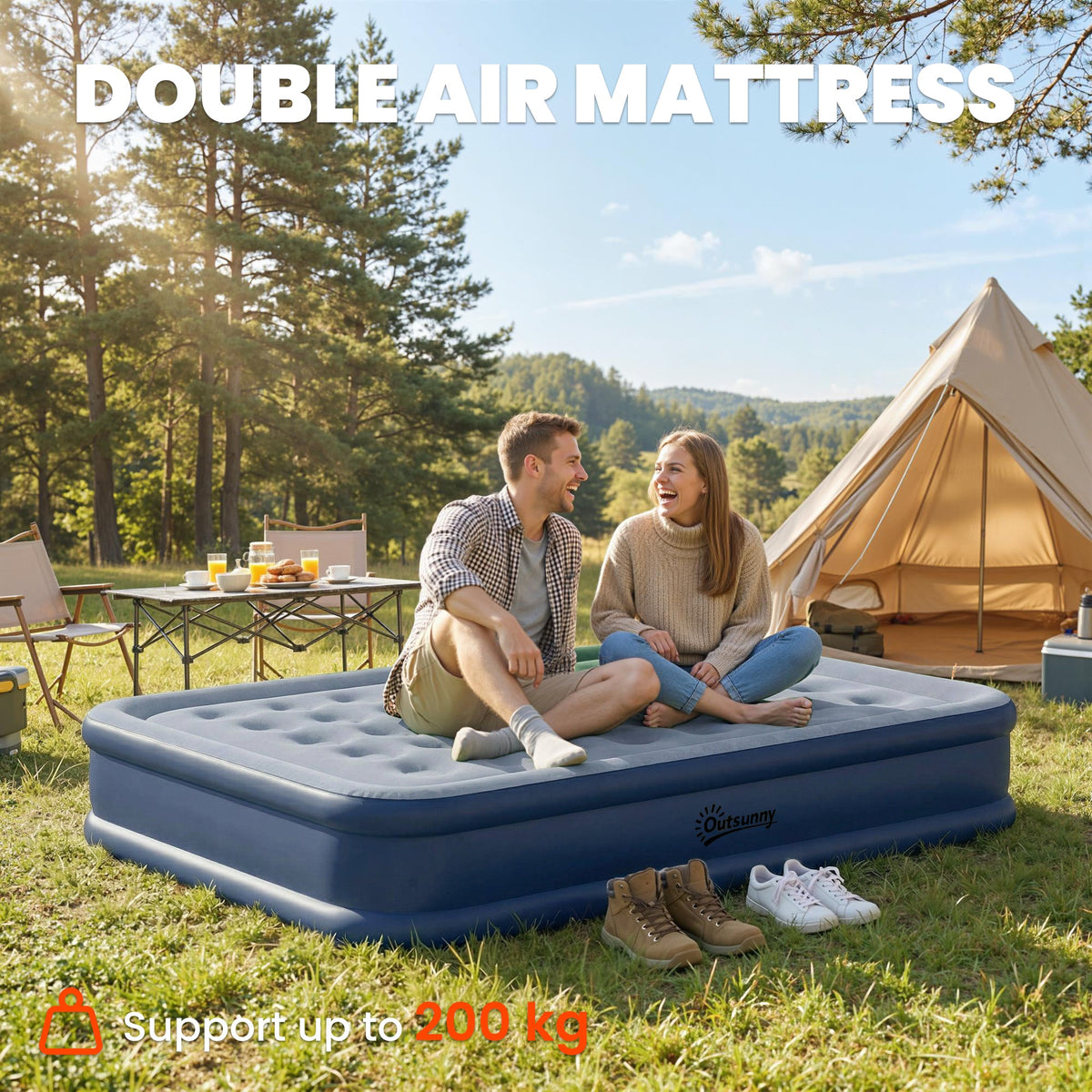 A couple sitting on the double air mattress outdoors with a tent in the background
