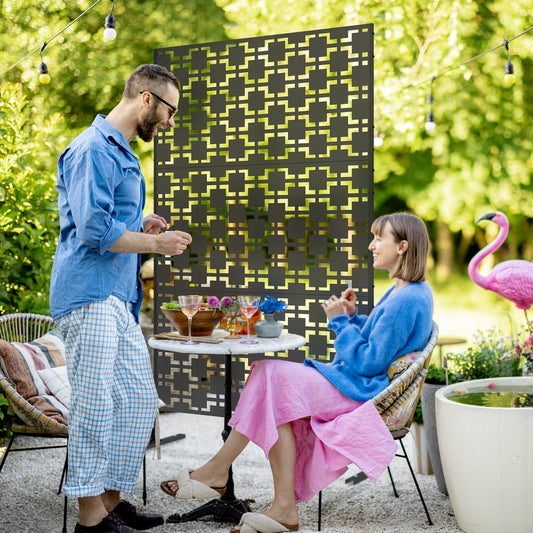 The decorative privacy screen used outdoors to divide a patio area with a table and chairs