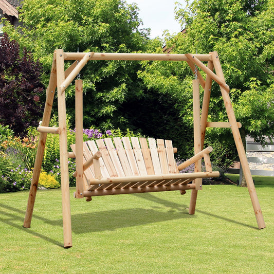 The wooden garden swing seat is set up on a lawn with green plants and flowers behind it
