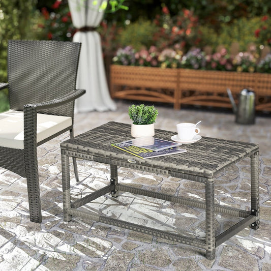 The rattan side table placed on a patio with a plant and a cup of tea on the surface