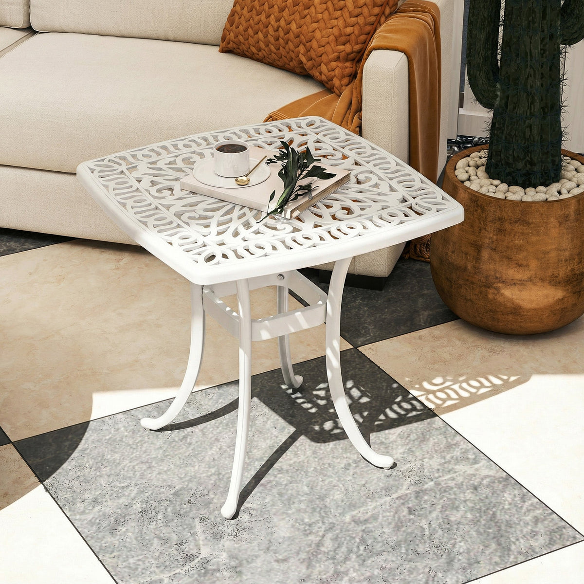 The garden table placed in a living room next to a sofa with a coffee cup on top