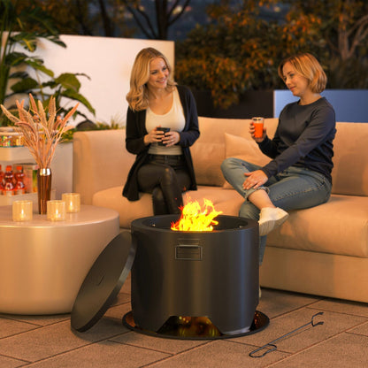 the round fire pit in use with a bright flame while two women sit on a sofa nearby