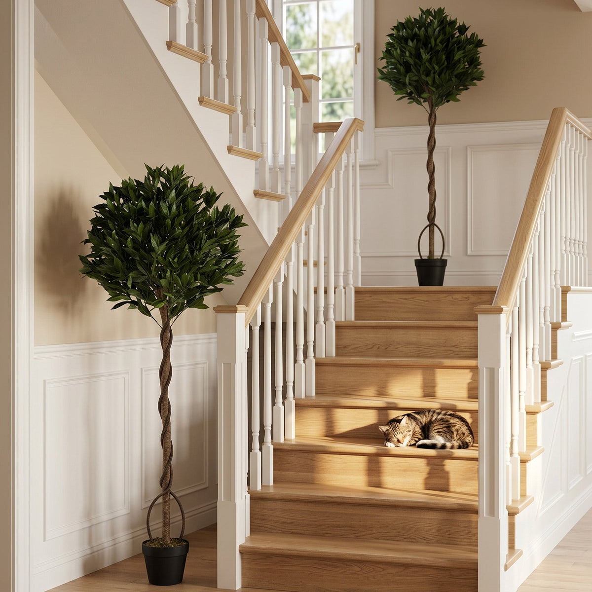 The artificial bay laurel trees placed on a wooden staircase indoors