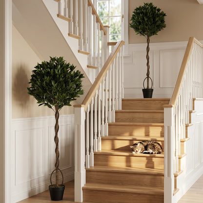 The artificial bay laurel trees placed on a wooden staircase indoors
