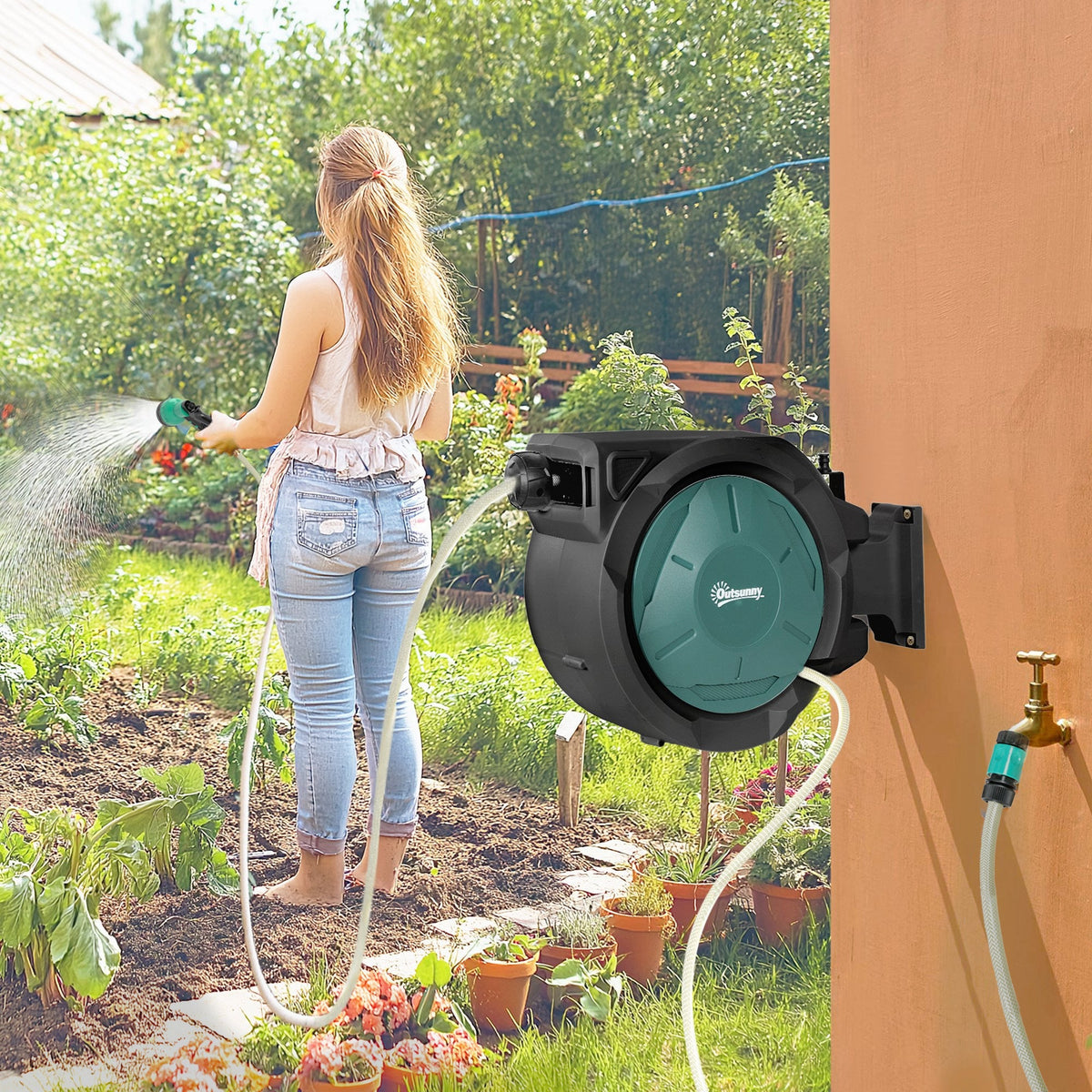 The garden hose reel in use watering plants in a sunny garden setting