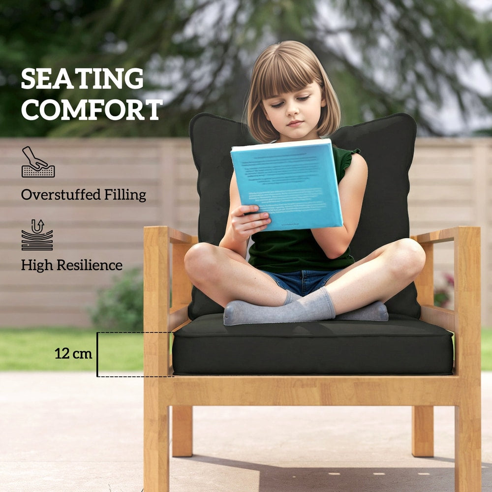 A girl sits on a wooden chair reading a book, with the black seat and back cushions providing comfort
