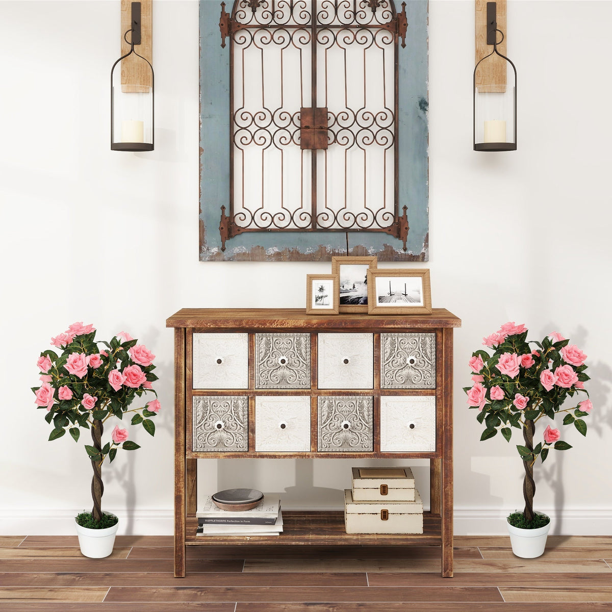 The artificial plants standing symmetrically on either side of a wooden console table