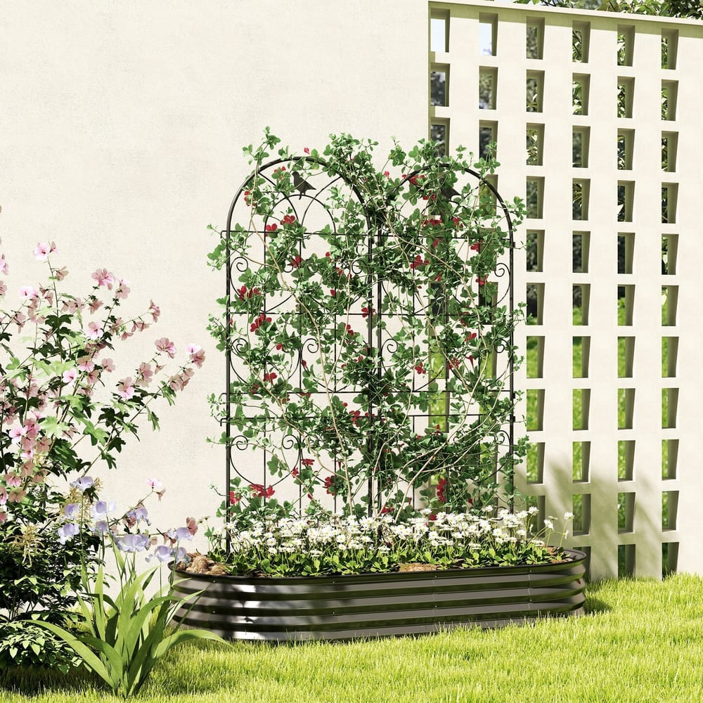 Two metal fence panels in a garden, supporting climbing plants in a raised flower bed