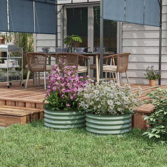 Two sage green raised garden beds filled with flowers on a wooden deck