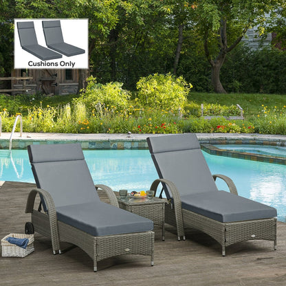 Two dark grey sun lounger cushions placed on rattan sun loungers by a swimming pool