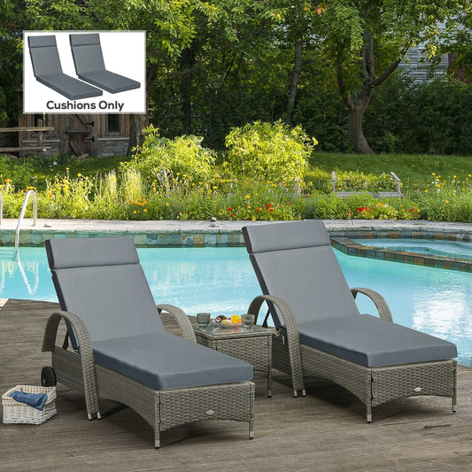 Two dark grey sun lounger cushions placed on rattan sun loungers by a swimming pool