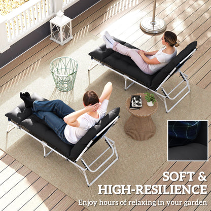 The sun lounger cushions in use by two people relaxing on a wooden patio with a small table