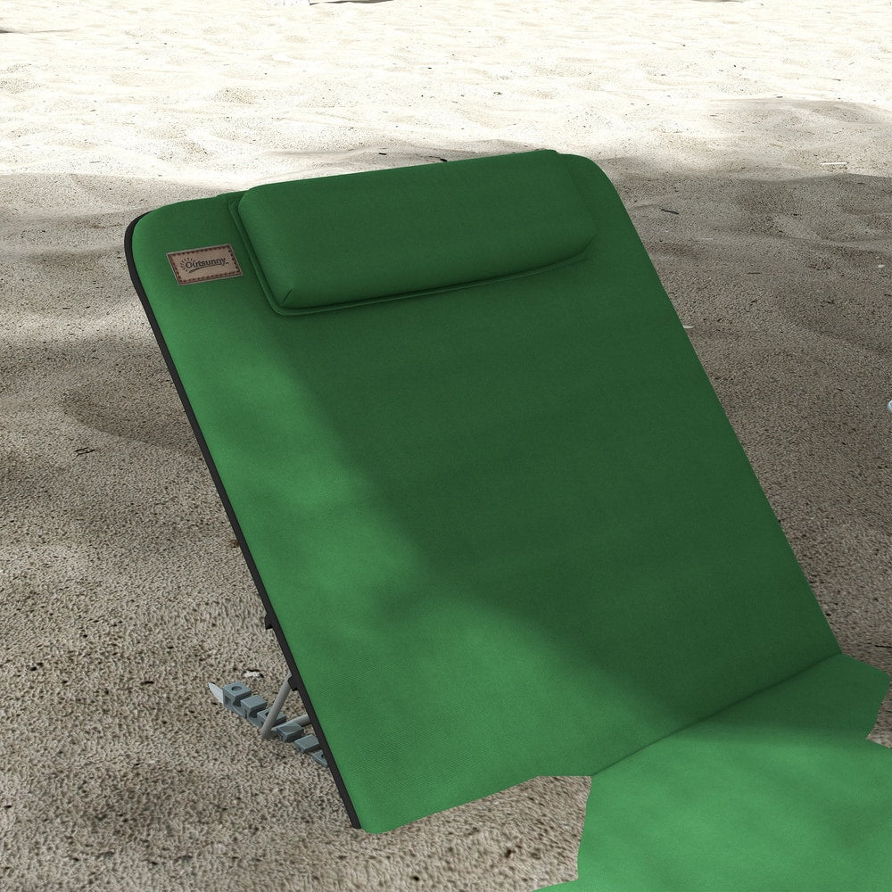 A single green metal frame beach chair on a sandy beach, angled view