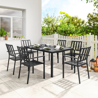 A black metal garden dining set with six chairs arranged around a table on a patio