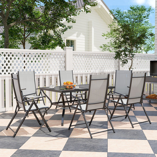 The garden dining set arranged on a patio with a white fence behind