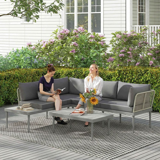 Two women relaxing on the grey rattan garden furniture set on a wooden deck