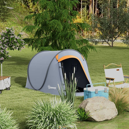 The grey pop-up dome tent set up in a garden with trees and grass, next to a cooler and chair