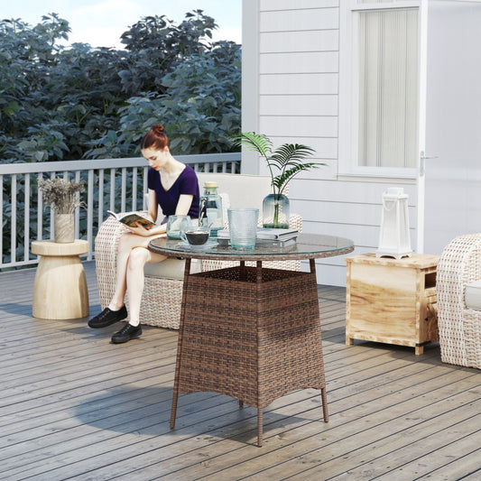The rattan furniture placed on a wooden deck with a woman sitting nearby reading a book