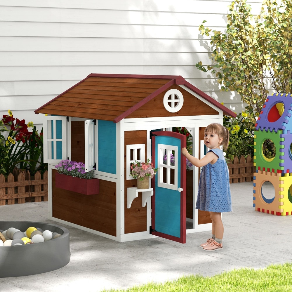 The wooden playhouse standing in a garden with a young girl opening the front door