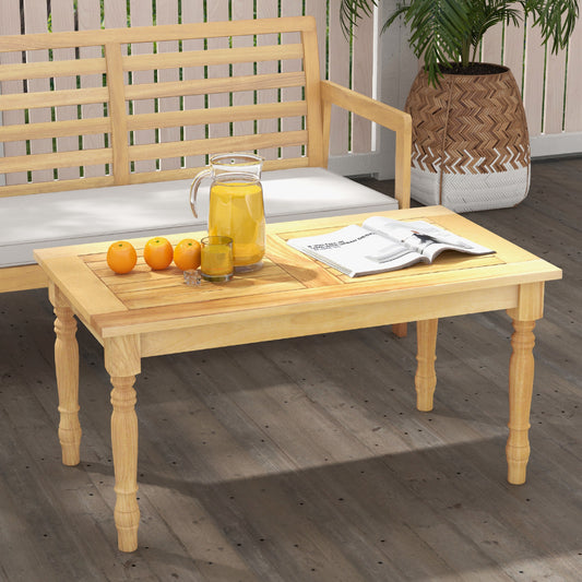The patio table placed in front of a wooden garden bench with a pitcher of juice and oranges