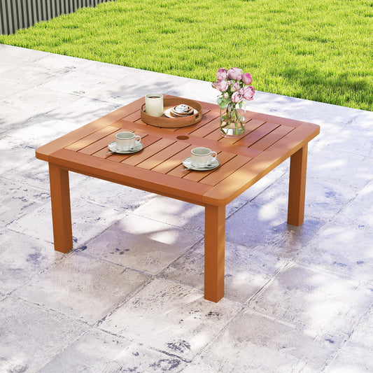 The patio table is set up on a paved patio with green grass and a fence in the background