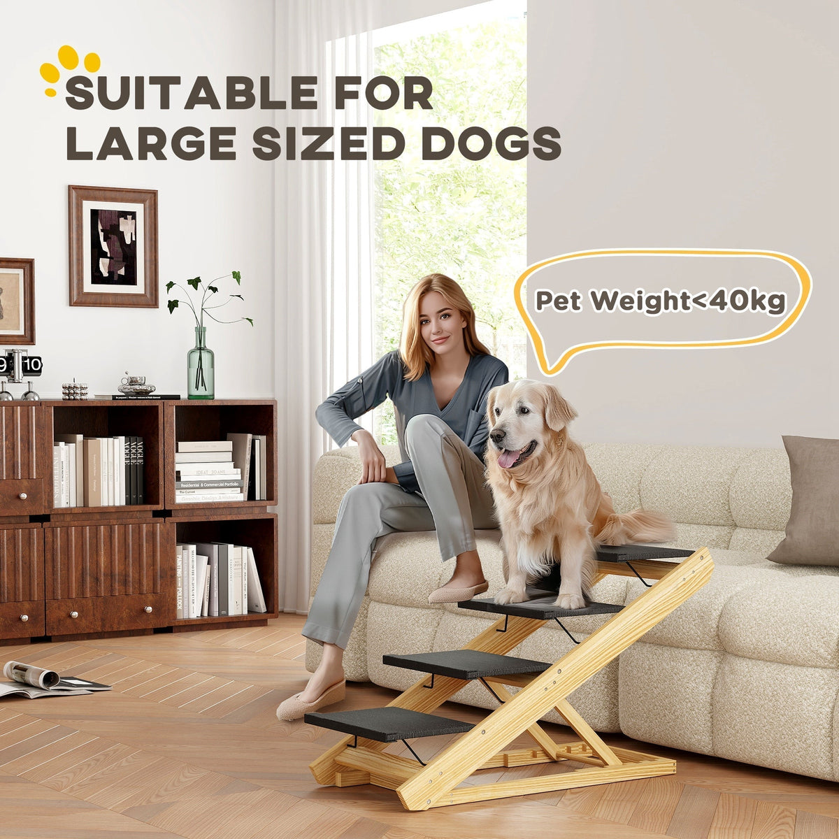 A large dog sitting on the pet steps next to a woman on a sofa