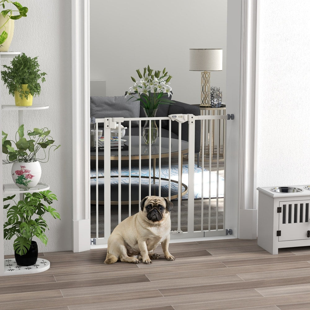 The white dog gate is installed in a doorway with a pug sitting in front of it